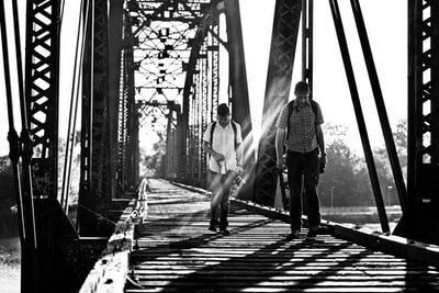 桥上两个人的灰度照片